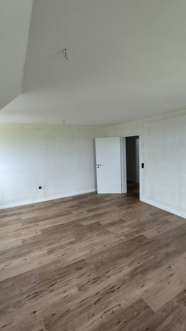 Fertiggestellter Wohnraum mit neuem Designboden und Zimmertür
